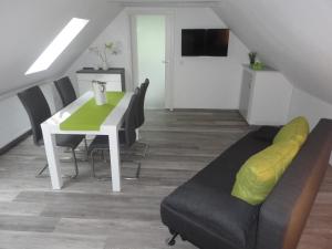 une salle à manger avec une table blanche et des chaises noires dans l'établissement Groß Kölzig - Moderne Ferienwohnung in ländlicher Idylle, à Neiße-Malxetal