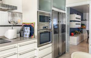 a kitchen with stainless steel appliances and white cabinets at Nice Apartment In El Campello With Wifi in El Campello