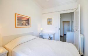 a white bedroom with a bed and a desk at 2 Bedroom Lovely Apartment In Genova in Genova +9 photos