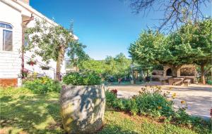 a garden with a tree stump in the grass at One-Bedroom Apartment Groznjan 01 in Grožnjan