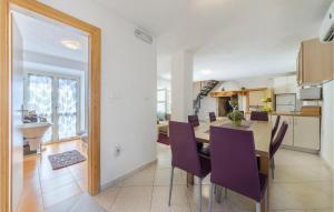 a kitchen and dining room with a table and purple chairs at Four-Bedroom Holiday Home Labin With Sea View 08 in Labin