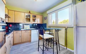 a kitchen with wooden cabinets and a bar with stools at Lovely Home In Saint-Maurice-Sur-Eygu in Saint-Maurice-sur-Eygues