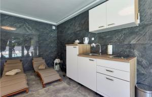 KapelaにあるStunning Home In Kapela With Kitchenの白いキャビネットと椅子付きのキッチン