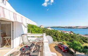 een balkon met uitzicht op de oceaan en een rode auto bij Amazing Apartment In Stara Novalja in Stara Novalja