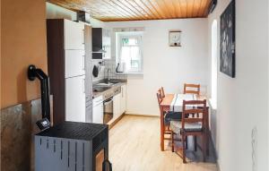 a kitchen with a table and a white refrigerator at Holiday Home Am Trieberweg S in Falkenstein