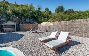a couple of chairs and an umbrella in a yard at Amazing Home In Kula Norinska With Wifi in Kula Norinska +45 photos