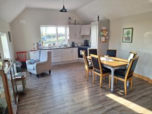 a kitchen and dining room with a table and chairs at Lough Lea House, Bunnamuca in Strokestown