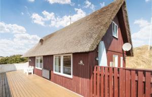 ein Haus mit Strohdach und Holzterrasse in der Unterkunft Holiday Home Hvide Sande 32 in Havrvig