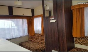 a small room with a bed and a window at CHEZ JOSETTE caravane Camping le sorbier Montignac Lascaux in Montignac