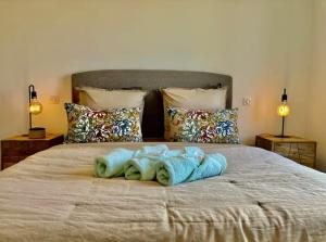 un lit avec des serviettes bleues dessus dans l'établissement La Casa de Betty, 4 personnes, Bord de Mer a Saint Florent, à Saint-Florent