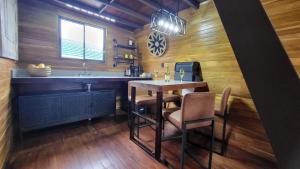 a kitchen with a table with chairs and a sink at Arenal 360 Lodge in Fortuna