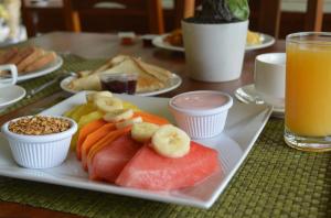 un piatto di frutta e verdura su un tavolo con il succo di Arenal Roca Suites a Fortuna