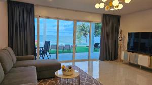 a living room with a view of the ocean at So Good Poolvilla and Appartments Family Room in Prachuap Khiri Khan