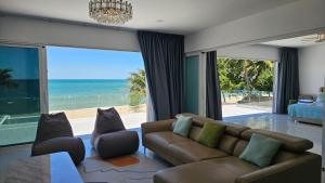 a living room with a couch and a view of the ocean at So Good Poolvilla and Appartments Family Room in Prachuap Khiri Khan