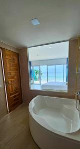 a large bath tub in a room with a view of the ocean at So Good Poolvilla and Appartments Family Room in Prachuap Khiri Khan