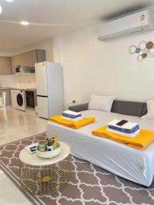 a bedroom with a large white bed with a table at So Good Poolvilla and Appartments Family Room in Prachuap Khiri Khan