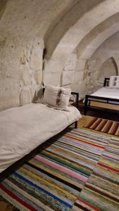 a bed in a room with a stone wall at KING SOLOMON PALACE in Avanos +47 photos
