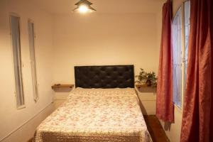 Schlafzimmer mit einem Bett mit schwarzem Kopfteil in der Unterkunft Tierra de Mariposas in Alta Gracia