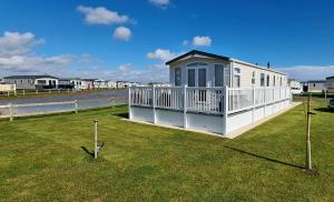 a small house with a porch on the grass at Golden Anchor Holiday Park- Europa Sequoia Private Static Caravan Hire - Wildflower Meadow - Chapel St Leonards in Chapel Saint Leonards