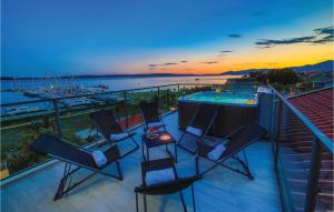 a group of chairs on a balcony with a swimming pool at Three-Bedroom Apartment In Kastel Gomilica in Kaštela