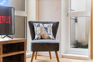 a chair with a pillow on it next to a window at Tranquil Telford Retreat with 2 Bedrooms in Telford