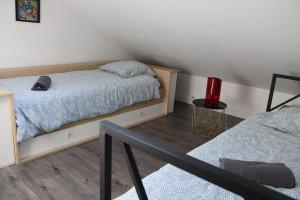 a bedroom with two beds and a red candle on the floor at Les Embruns in Neuville-lès-Dieppe
