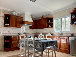 a kitchen with a table with chairs and a sink at Casa Caloura Lotus Deluxe Accommodation & Spa in Lagoa