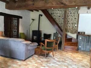 a living room with a couch and a table and chairs at Les Bouis in Saint-Hilaire