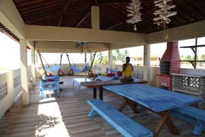 a porch with blue picnic tables and swings at Casabella in Lucena