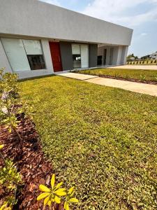 a building with a grass yard in front of it at Casa Borges in Paraná