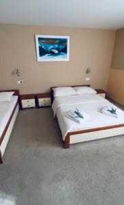 a bedroom with two beds and a painting on the wall at Hotel Snezna Kraljica Jahorina in Jahorina