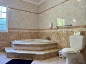 a bathroom with a tub and a toilet at Casa Caloura Lotus Deluxe Accommodation & Spa in Lagoa +18 photos