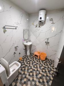 a bathroom with a sink and a toilet and a mirror at Hotel Goyal Palace in Agra