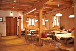 a dining room with wooden floors and tables and windows at SCHENE Kammer in Abtenau