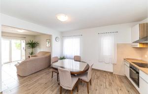 a kitchen and living room with a table and chairs at Amazing Apartment In Kastel Stari in Kastel Stari