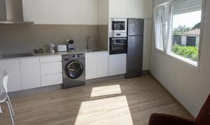 a kitchen with a washer and dryer in it at Alén de Louro - Apartamento 3 Ancoradoiro in Gándara