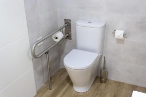 a bathroom with a toilet and some toilet paper at Alén de Louro - Apartamento 3 Ancoradoiro in Gándara +7 photos