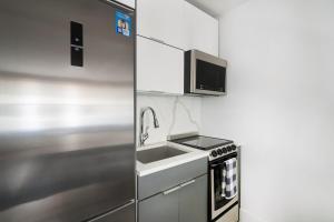 a kitchen with a sink and a microwave at 1597-7 Luxury Upper East Studio W&D in unit in New York