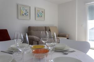een tafel met wijnglazen en borden erop bij Alén de Louro - Apartamento 4 Lariño in Gándara