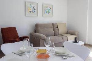 een woonkamer met een tafel en een bank bij Alén de Louro - Apartamento 4 Lariño in Gándara +11 foto's