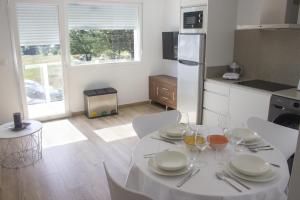 een keuken met een tafel met borden en wijnglazen bij Alén de Louro - Apartamento 4 Lariño in Gándara