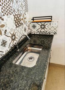 a kitchen counter with a sink in a kitchen at Chalé Beija Flor com piscina em Sapucaí-Mirim in Sapucaí-Mirim