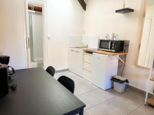 eine Küche mit Tisch und Mikrowelle in der Unterkunft Studio SN9 - Centre-Ville Meaux - Proche Disneyland in Meaux