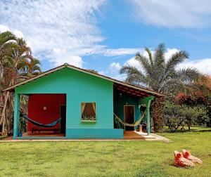 a small house with a green and red at Respire Fundo A Natureza te Espera - Estância do Caminho do Meio in Caldazinha