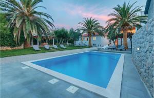 a swimming pool in a yard with palm trees at Nice Home In Zdrelac With Sauna in Ždrelac