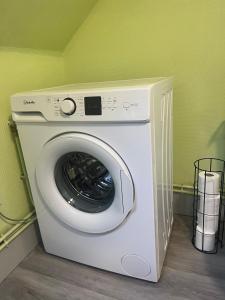 a washing machine in a room with a green wall at La Bêtise in Cambrai