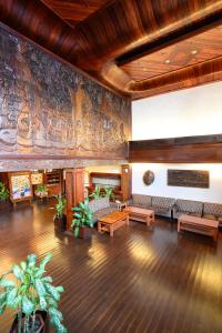 a lobby with couches and a wall with a mural at Airai Water Paradise Hotel & Spa in Koror