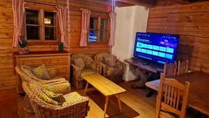 a living room with a television and a table and chairs at DIRNDL Kammer in Abtenau