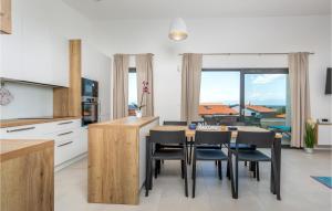 kuchnia i jadalnia ze stołem i krzesłami w obiekcie Pet Friendly Apartment In Malinska w mieście Malinska