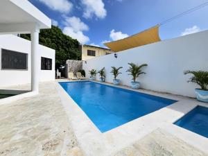 a swimming pool in the backyard of a house at Villa DMM con piscina, jacuzzi y gran área verde en Punta Cana in Punta Cana
